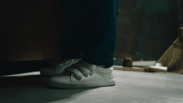 Person's legs wearing white sneakers