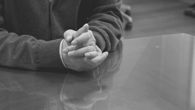 테이블 위에 깍지 낀 손