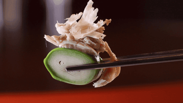 Chicken and pumpkin slices held with chopsticks