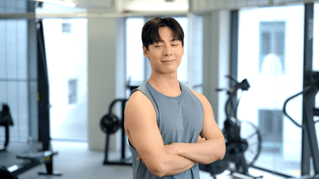 체육관에서 자신감 있게 서서 정면을 보는 젊은 남성