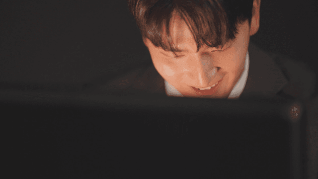 Man in a suit smiling as he opens a briefcase