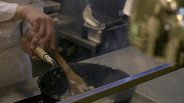 Chef cooking with flames in kitchen