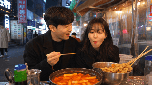 Couple eating tteokbokki on street
