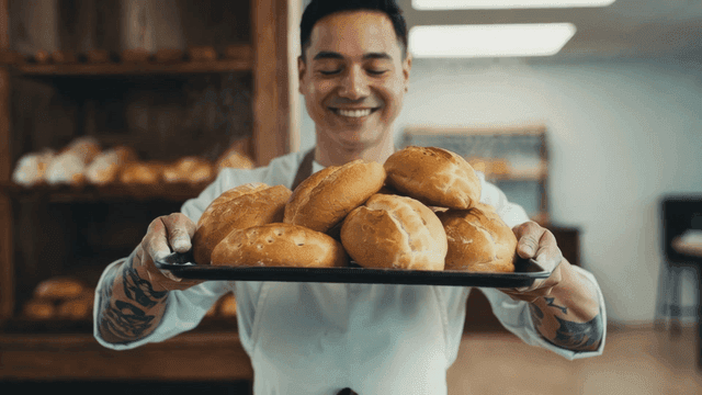 Baker presenting freshly baked bread