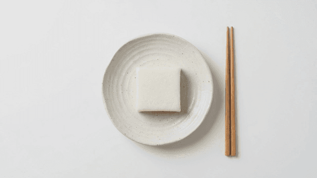 Square white rice cake placed on plate