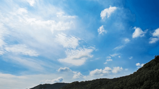 Clear blue sky with fluffy clouds