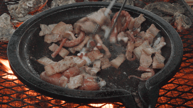 Pork belly and octopus grilling on hot plate