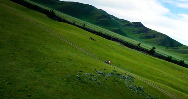 녹색 언덕을 달리는 오토바이