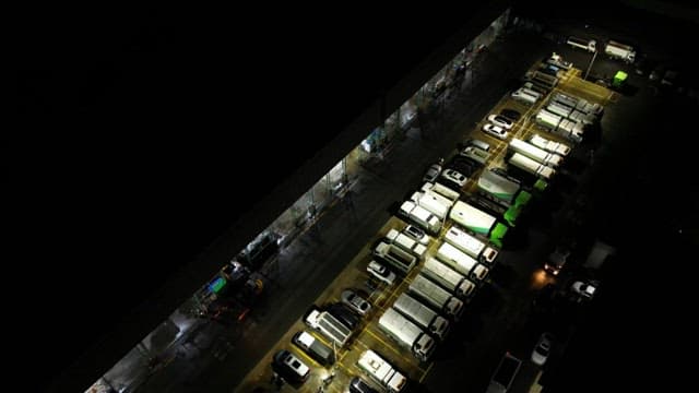 Waste management facility lined with vehicles at night