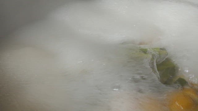 주방에서 큰 솥에 채소와 육수를 준비하는 모습