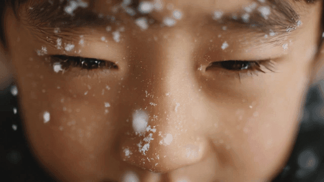 눈송이로 덮인 아이의 얼굴