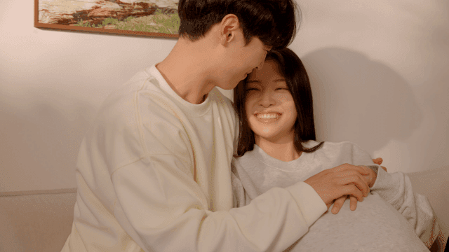 집에서 편히 앉아 있는 임신한 부부