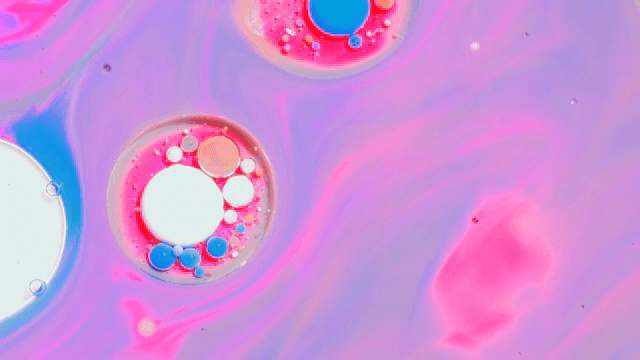 보라색과 분홍색 액체 속의 다채로운 버블들
