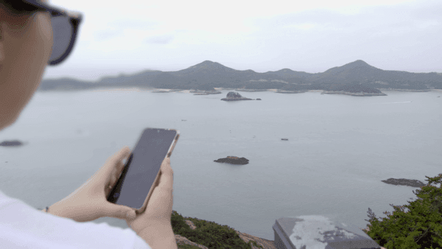 해안 경치를 사진 찍는 여성