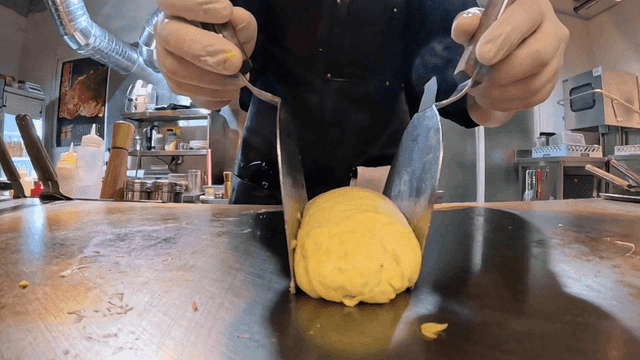 Chef preparing an omelette on a hot grill