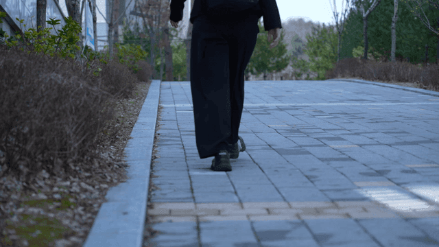 Back of woman walking along quiet park path