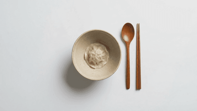 Dumplings in bowl along with chopsticks
