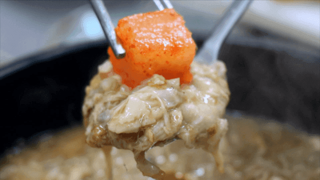 상황버섯 삼계탕 죽과 깍두기를 담은 숟가락