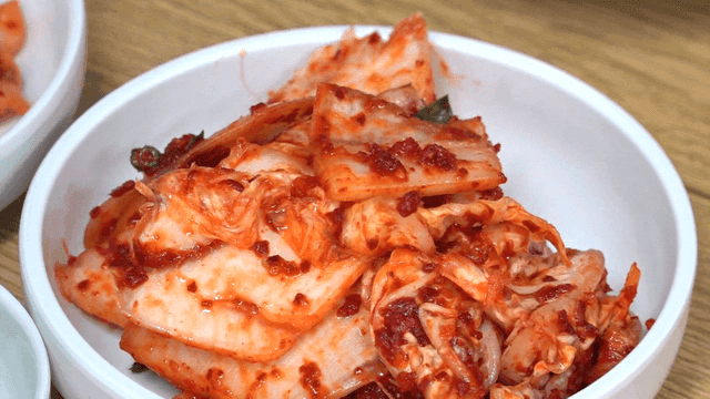 Bright red kimchi on a white plate