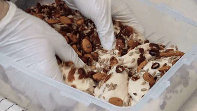 Baker mixing nuts and dried cranberries into dough
