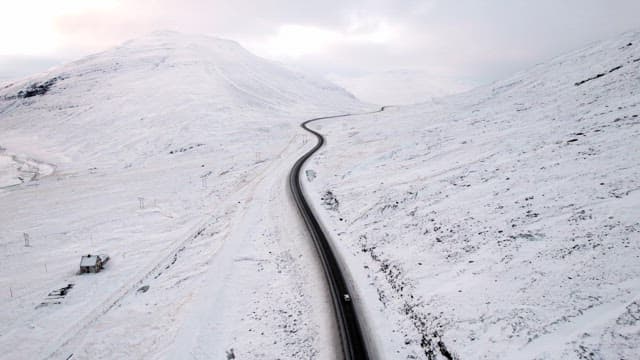 Car driving on a snowy mountain road