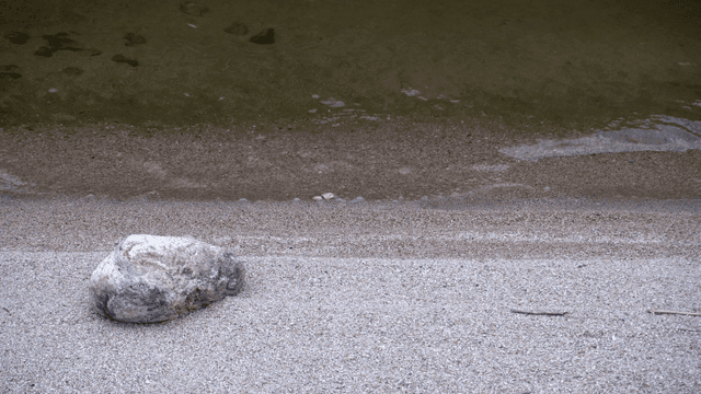 고요한 강가의 모래사장과 바위