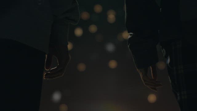 어두운 밤, 희미한 불빛 사이로 손을 잡는 연인