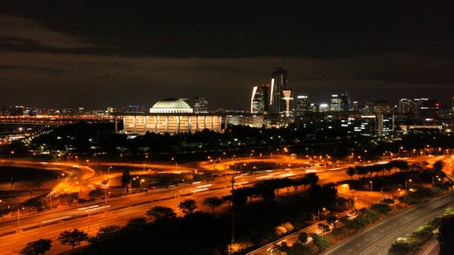 Cityscape at Night with Illuminated Roads and Buildings