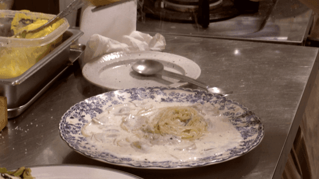 Creamy pasta being prepared in a kitchen