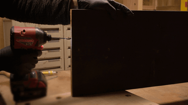 작업실에서 나무 판에 전동 드릴 작업