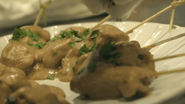 Skewered meat with sauce and herbs
