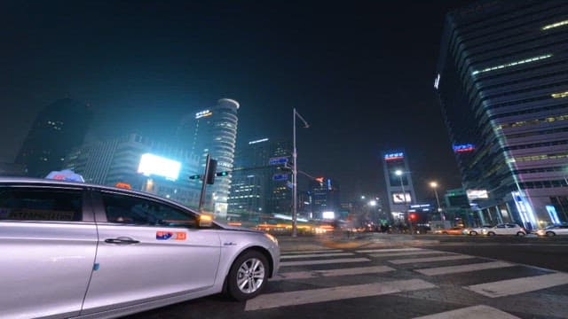 Cityscape Illuminated by the Lights of Running Vehicles