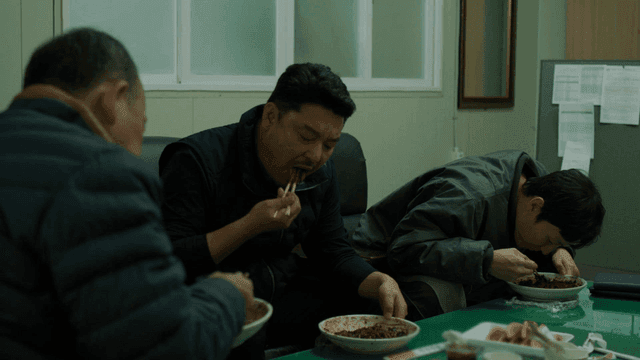 Three men eating jajangmyeon in office