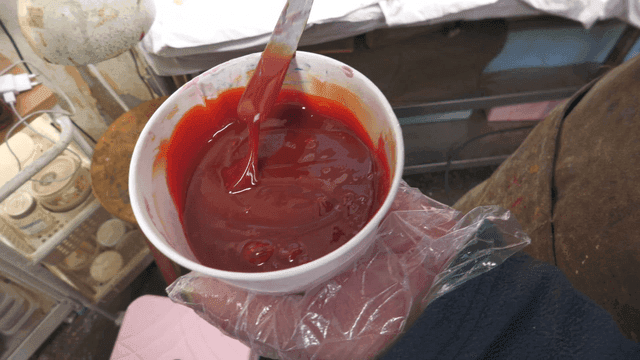 Artist mixing red dye in bowl
