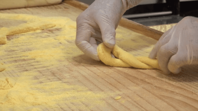 밀가루를 뿌린 표면에서 반죽을 모양내는 손