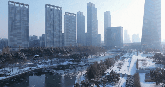 Snow-covered traditional Hanok buildings and city skyline