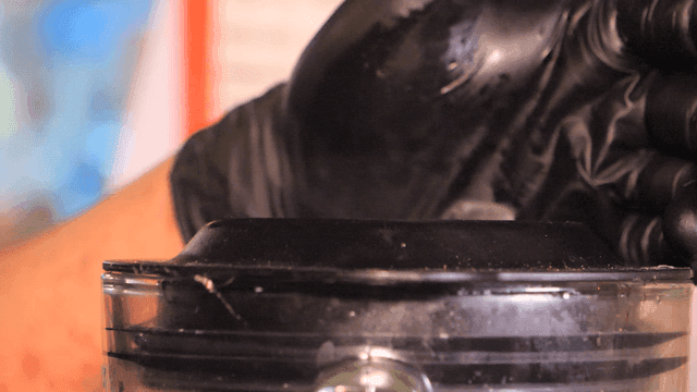 Smoke coming from blender pressed down by glove