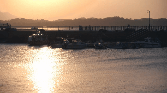 보트가 있는 고요한 항구의 일몰