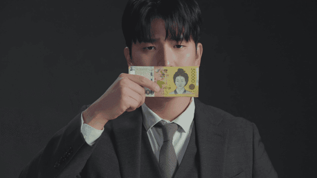Man with a frustrated expression covering his mouth with money