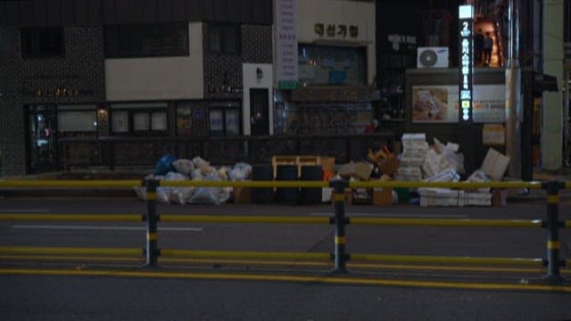 자동차가 지나가는 밤의 텅 빈 도시 거리와 쓰레기들