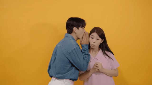 Man and a woman talking quietly, whispering and sharing secrets