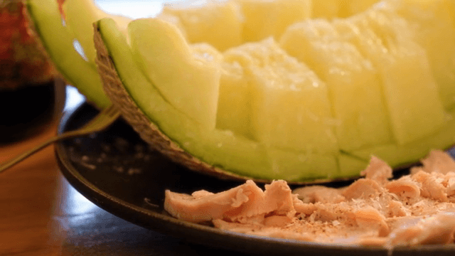 Sliced melon and salmon on a plate