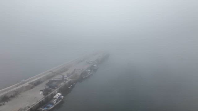 Foggy harbor with ships docked