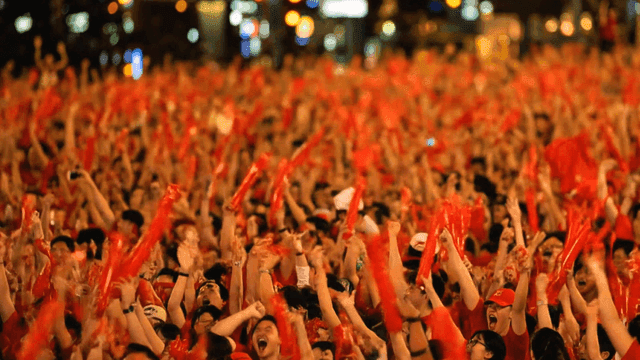 Large crowd waving red flags