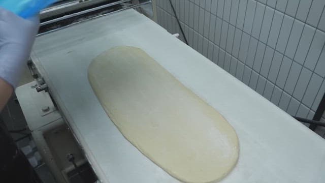 Person preparing bread dough and butter in a bakery