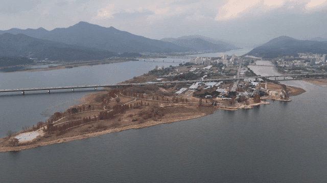 Scenic river with bridges and mountains.