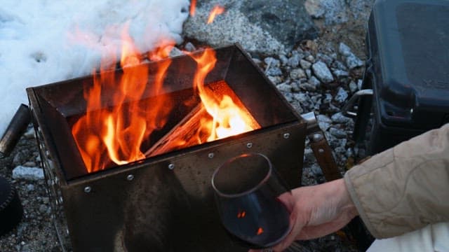 Enjoying wine with a campfire on a portable stove