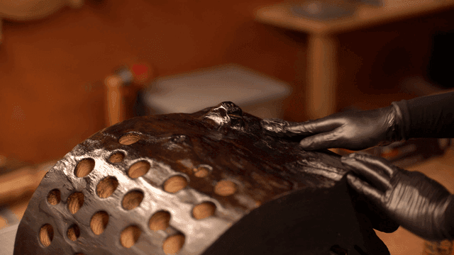 나무 조각에 마감 오일을 바르는 장인