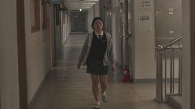 Female student walking through the school hallway with a stern expression