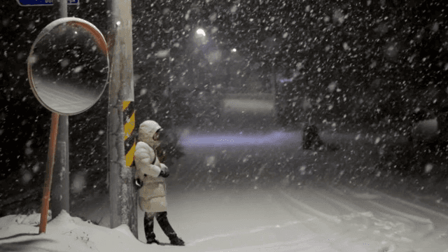 Person standing on a snowy night street